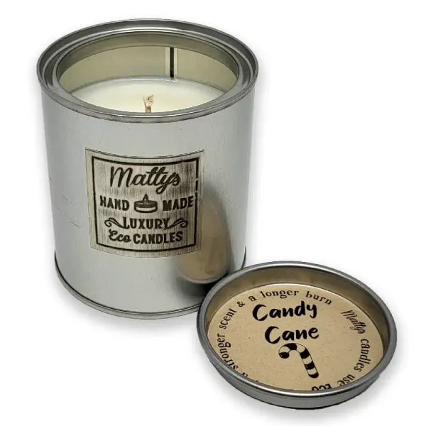 A silver tin labeled “Matty’s Handmade Luxury Eco Candles” with the lid off reveals a white Candy Cane Scented Candle. The lid says “Stronger scent & a longer burn. Candy Cane” and features a candy cane illustration.